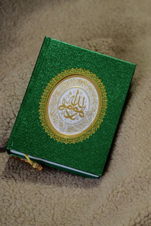 Un libro del Corán con una cubierta verde brillante, separadores de página y escritura de oro en la cala