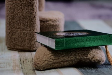Un libro del Corán con una cubierta verde brillante, separadores de página y escritura de oro en la portada