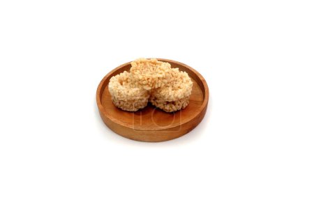 Rengginang oder Rangginang, traditionelle indonesische Reiskräcker, die aus Reis oder Klebreis hergestellt werden. Herzhaft und knusprig. Serviert auf einem Holzteller und isoliert auf weißem Hintergrund.