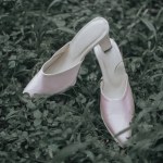 close up of the bride's white high heels on the grass