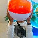 man holding beach ball in front of his face