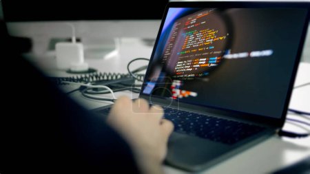 Programmation. Homme travaillant à l'ordinateur dans un bureau informatique, écrivant des codes assis au bureau. Programmeur écrit le code de données, travaillant sur le projet à la société de développement de logiciels. Image de haute qualité.