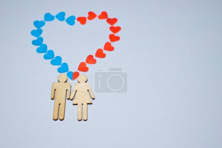 Männer und Frauen lieben LGBT. In der Ehe die Ikonen der Familie. Liebespaar. Eine Frau und ein Mann halten sich an den Händen. Holzmenschen mit blauen und roten Herzen aus Papier
