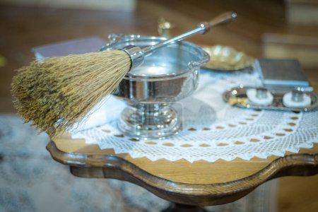 Photo for Liturgical vessels with holy water in the church. Broom for lighting in the church with holy water. Soft selective focus. Artificially created grain for the picture - Royalty Free Image