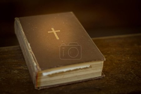 Photo for Bible on the church bench. God's word in one little book. Soft selective focus. Artificially created grain for the picture - Royalty Free Image