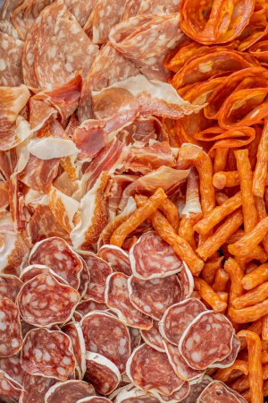 Photo for Cured meat with toppings. Homemade salami, chorizo and other cured sausages. Dried sausages cut into thin slices - Royalty Free Image