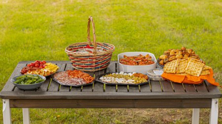 Photo for Picnic table with various snacks. Sweet and salty snacks with cheese and meat - Royalty Free Image