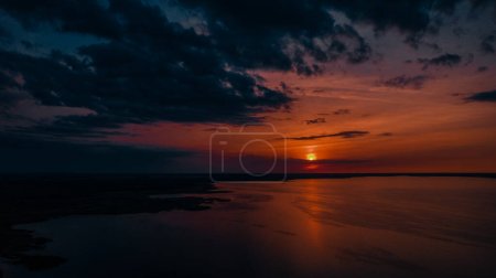 Photo for Red sunset by the lake. Hot weather at sunset. Dramatic red sunset at desert. Heatwave hot sun. Climate Change. Global Warming. - Royalty Free Image