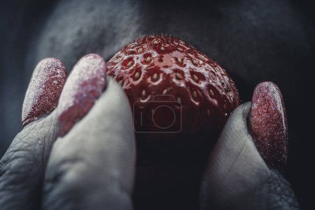 Photo for Wild strawberry in women's fingers. Juicy strawberry On the lips - Royalty Free Image