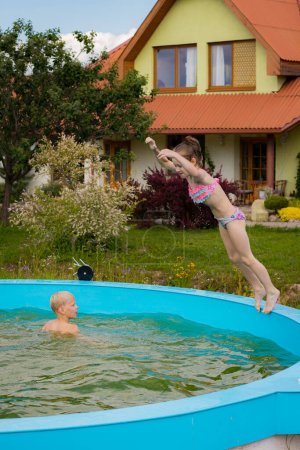 Photo for Children swim alone in the pool. Children by the pool. Children's safety near water bodies - Royalty Free Image