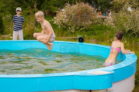 Photo for Children swim alone in the pool. Children by the pool. Children's safety near water bodies - Royalty Free Image