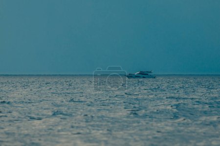 Foto de Barco recreativo en un mar de aire caliente arremolinándose. Lancha a motor en el horizonte del mar en clima cálido. Distorsiones atmosféricas, distorsiones del aire caliente, distorsiones del calor, refracción del aire - Imagen libre de derechos