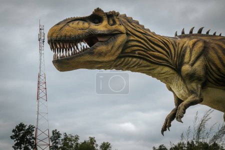 Foto de Una torre de comunicación con un dinosaurio en el fondo. Torre de señal con grandes precios. Un concepto con altas tasas de comunicación. - Imagen libre de derechos
