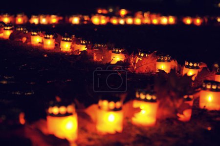 Photo for Burning memorial day candles burn on the ground. Soft selective focus - Royalty Free Image
