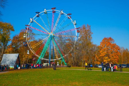 Foto de Rueda panorámica en Sigulda en otoño. La gente se está relajando en el parque cerca de la noria. - Imagen libre de derechos