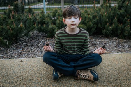 Photo for Boy sits and meditates. The child rests and meditates. Smiling happy child - Royalty Free Image
