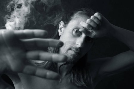 Téléchargez les photos : Portrait de jeune homme en fumée - en image libre de droit