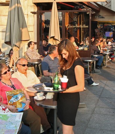 Téléchargez les photos : Serveuse dans un café extérieur, Paris - en image libre de droit