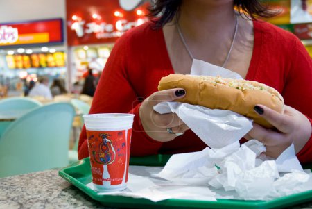 Téléchargez les photos : Femme manger Fast Food - en image libre de droit