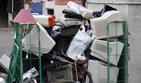 Téléchargez les photos : Pile de déchets électroniques et ménagers usagés dans la rue de la ville, prêts pour le recyclage - en image libre de droit