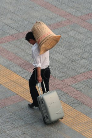 Téléchargez les photos : Homme chinois occupé avec des bagages - en image libre de droit
