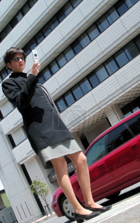 Téléchargez les photos : Femme avec téléphone sur fond de ville - en image libre de droit