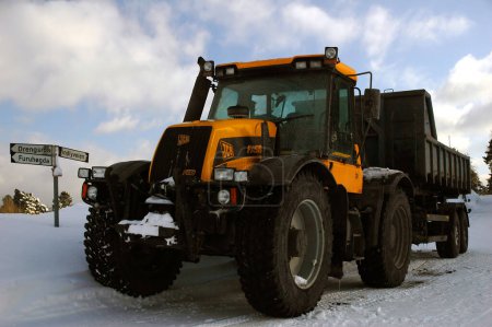 Téléchargez les photos : Tracteur sur route enneigée en hiver - en image libre de droit