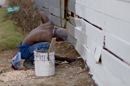 Foto de Un hombre está pintando una cerca con color blanco - Imagen libre de derechos