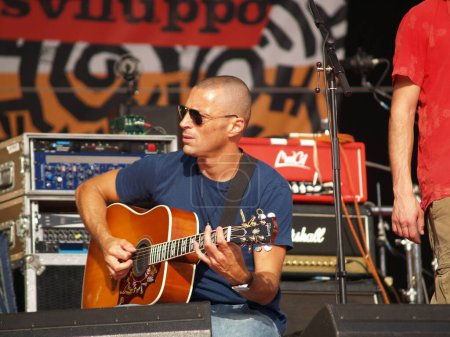 Téléchargez les photos : Le groupe du guitariste joue de la guitare au concert, Alex Britti - en image libre de droit