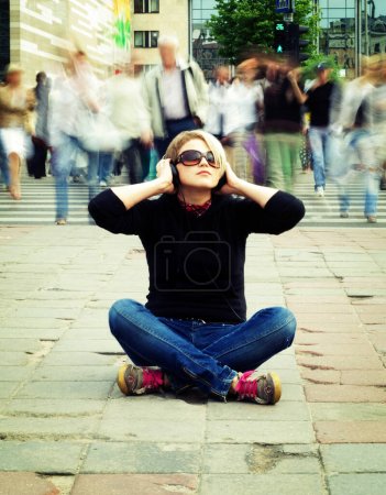 Téléchargez les photos : Vitesse de vie. femme dans les écouteurs assis sur steet - en image libre de droit