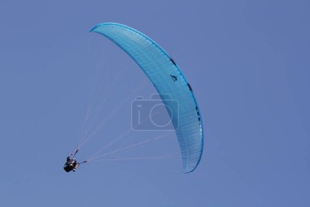 Téléchargez les photos : Parapente volant dans un ciel bleu clair - en image libre de droit