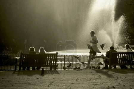 Téléchargez les photos : Homme courant dans le parc le long des fontaines - en image libre de droit