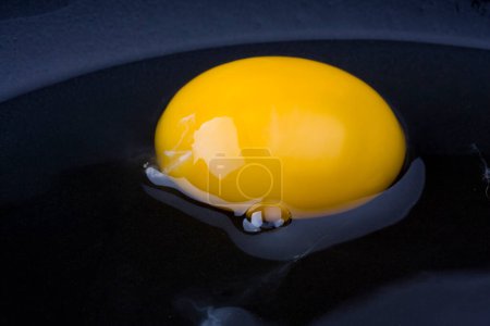 Photo for Egg yolk in a black pan - Royalty Free Image