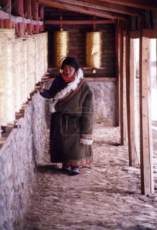 Foto de Woman using Praying wheels - Imagen libre de derechos