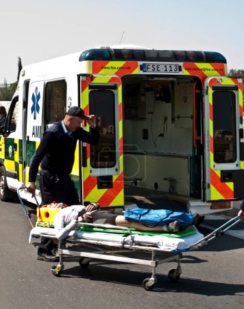 Photo for Injured Cyclist transporting in ambulance car - Royalty Free Image
