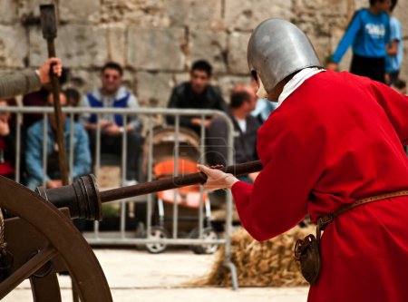 Photo for Man holds medieval cannon - Royalty Free Image