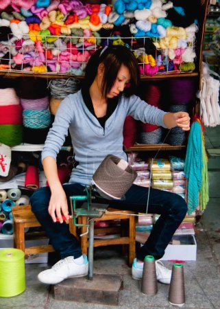Foto de Ciudad de Guilin: mujer hilando lana. - Imagen libre de derechos