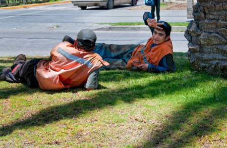 Téléchargez les photos : Travailleurs de la construction reposant sur l'herbe - en image libre de droit
