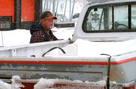 Téléchargez les photos : Homme avec camion dans la neige fumeur - en image libre de droit