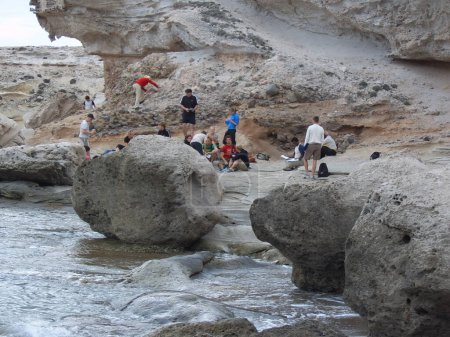Foto de Turistas estudiando la costa rocosa - Imagen libre de derechos