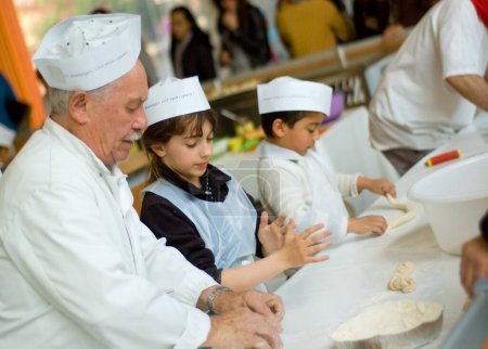 Téléchargez les photos : The Show of bread in Paris, 2010. Vieux boulanger enseigne aux enfants à faire du pain - en image libre de droit