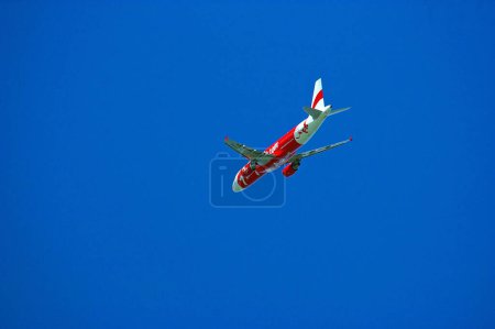 Téléchargez les photos : Un avion économique qui vole dans le ciel - en image libre de droit