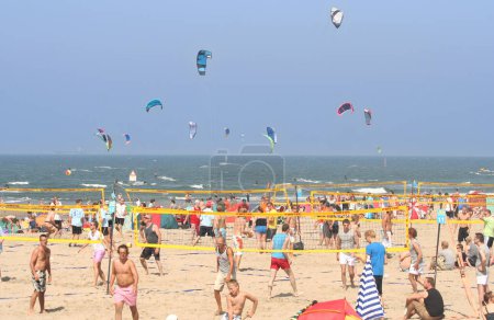 Téléchargez les photos : Personnes jouant au beach volley et au kitesurf - en image libre de droit