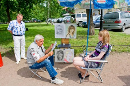 Téléchargez les photos : Dessin d'artiste portraits en plein air dans la ville - en image libre de droit