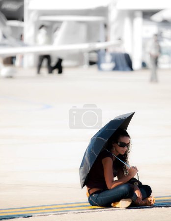 Téléchargez les photos : Femme assise avec un parapluie sur le fond - en image libre de droit