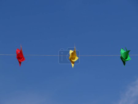 Photo for Red yellow green windmills on sky - Royalty Free Image
