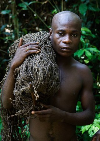 Téléchargez les photos : Pygmée chasseur avec un filet. Le chasseur-pygmée avec un filet avant la chasse - en image libre de droit