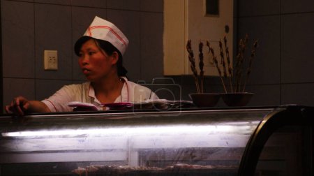 Photo for Chinese woman behind the counter of the beijing snack - Royalty Free Image