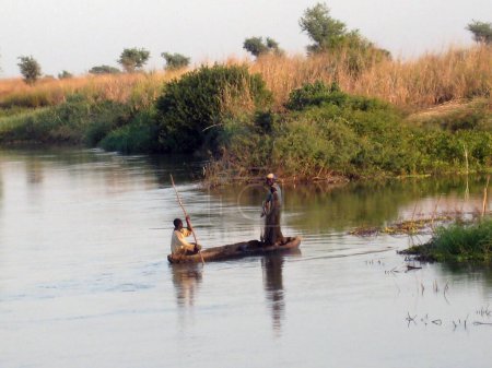 Téléchargez les photos : African fishermen on wooden boat - en image libre de droit
