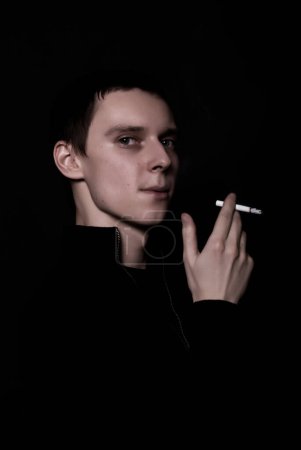 Téléchargez les photos : Portrait d'un jeune homme avec cigarette - en image libre de droit
